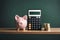 Piggy bank, calculator, money on wooden table against pastel color wall background