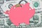 Piggy bank on dollar banknotes and coins - Saving money concept