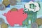 Piggy bank dreaming about graduation on euro banknotes and coins - Saving money for graduation concept