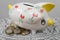 Piggy bank in the form of a painted pig. A handful of coins