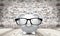 Piggy bank in glasses on brick wall background