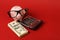 Piggy bank with glasses standing on stack of money and calculator
