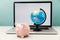 Piggy bank and globe on a laptop. Global online banking concept