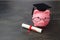 Piggy bank with a grad cap and diploma on wooden table, Education scholarship