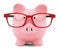 Piggy bank in red glasses on white background