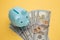 Piggy bank with rings on money banknotes on yellow background. Save up for honeymoon, wedding trip
