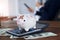 Piggy bank in sick and injury standing on calculator among money and coin on table in office