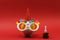 Piggy bank with sunglasses Happy birthday, party hat and birthday cake with candle on red background