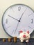 Piggy bank and tower coins on background of clock. Copy space.