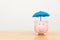 Piggy bank and umbrella on wooden table