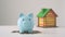 Piggy coin bank and house model on white wooden background. Savings for buying house concept