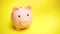 Piggy moneybox at yellow background