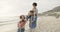 Piggyback, children and a blended family at the beach, walking on sand together for travel or vacation. Mother, father