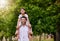 Piggyback, portrait and father with child in a park happy, playing and having fun together. Shoulder, games and face of