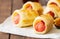 Pigs in a planket - puff pastry rolls with sausages on a wooden background