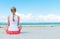 Pigtailed girl sitting on the beach.