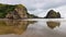 Piha black sand beach featuring cliffs and rock formations in New Zealand