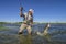 Pike fishing. Happy fisherman fights with big fish in water at river