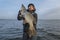 Pike fishing. Happy fisherman holding big fish at boat