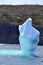 Pilar shaped iceberg in bay outside St. John\\\'s next to seaside cliff