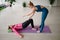 Pilates instructor trains a woman in sportswear in the gym, corrects posture. Rehabilitation after injury.