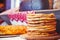 Pile of air pancakes on a wooden dinette, a traditional food family. golden pancakes, pies in the background