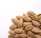 A pile of almonds on a white background. Salted fresh nuts in the shell lie in a handful isolated from the background.