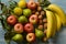 Pile of apples, pears, walnuts and bananas on light blue wooden table