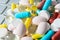 Pile of assorted medicine pills and capsules on gray keyboard, macro pharmaceutical background.