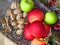 A pile of autumn fruit top view on brass bowl background. Green red apples, walnuts and a bunch of cinnamon . Rustic style photo.