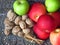 A pile of autumn fruit top view on brass table background. Green red apples, walnuts and a bunch of cinnamon . Rustic style photo.