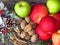 A pile of autumn fruit top view on brass table background. Green red apples, walnuts and a bunch of cinnamon . Rustic style photo.