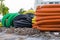 Pile of big industrial plastic corrugated pipes on ground