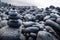 Pile of black lava stones at coastline at Puerto de la Cruz, Tenerife, Canary Islands, Spain