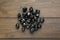 Pile of black rune stones on wooden table, flat lay