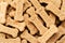 Pile of Bone shaped dog biscuits of brown color. Abstract wallpaper