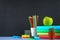 A pile of books and stationery on a chalkboard background. Work desk, education, school.
