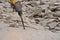 Pile of broken concrete, worker smashes concrete floor with electric hammer drill