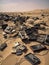 A pile of broken electronic equipment strewn across the desert sand.. AI generation