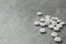 Pile of calcium supplement pills on grey table, space for text
