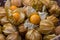 Pile of cape gooseberry on sale in the market. Physalis Fruits on a black basket background.