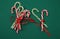 Pile Caramel sugar canes tied with a red ribbon on a green background. Christmas background. Concept of Christmas and New Year.