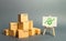 A pile of cardboard boxes and a stand with green arrow up. Increasing consumer demand. rate growth of production of goods