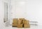 Pile of cardboard boxes in white minimalist white home hallway. Lot of room for text.