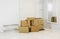 Pile of cardboard boxes in white minimalist white home hallway. Lot of room for text.