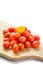 Pile of cherry tomatoes on a wooden cutting board