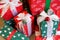 A pile of Christmas gifts in colorful red and green wrapping with ribbons