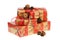 Pile of Christmas gifts wrapped with red and golden paper with ornaments and red glitter ribbon, decorated with pine cones.