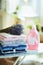 Pile of clothes, softener and bunch of lavender on ironing board