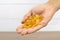 Pile of cod liver oil capsule dietary supplement in hand for health-care